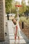 A little girl with a brush cleans a path on the street in the courtyard