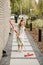 A little girl with a brush cleans a path on the street in the courtyard