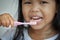 Little girl brushing her teeth close up on toothbrush