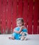 Little Girl with Bunny next to Red Fence