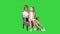Little girl calling mobile phone with her mother on a green screen, chroma key