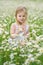 Little girl in camomile meadow