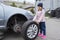 Little girl in a car service, on replacing wheel tires and servicing a vehicle suspension.  Auto repair concept