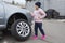 Little girl at a car service. Replacing wheels on a car. Repair service