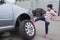 Little girl at a car service. Replacing wheels on a car. Repair service