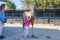 Little girl caressing a horse next to her mother outside of stab