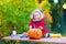 Little girl carving pumpkin at Halloween