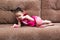 Little girl with cat face painting play ball on couch