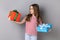 Little girl celebrating her birthday, holding two present boxes in hands, being happy with gifts.