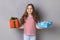 Little girl celebrating her birthday, holding two present boxes in hands and looking at camera.