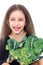 Little girl cheerfully holding head of broccoli and smiling