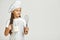 Little girl in chef hat and apron with flour in measuring cup and whisk.