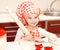 Little girl with chef hat and rolling pin is going to bake cookies