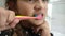 Little girl child brushing teeth with a toothbrush