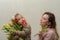 Little girl child, daughter gives mom a bouquet of flowers of colorful tulips - happy family