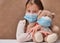 Little girl child holding a teddy bear wearing a mask. Concept of health care and virus protection covid