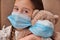 Little girl child holding a teddy bear wearing a mask. Concept of health care and virus protection covid