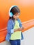 Little girl child listens music in headphones and using smartphone