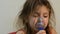 Little girl child makes inhalation with mask on face