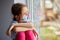 Little girl, child in mask sits on windows, coronavirus quarantine
