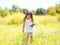 Little girl child on meadow picking chamomiles flowers