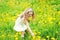 Little girl child in meadow picking yellow dandelion flowers