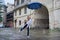 Little girl child in the rain with an umbrella, tourist old city background