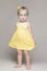 Little girl child in yellow dress with short hair and bow. happy childhood.