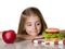 Little girl choose between apple and hamburger.Unhealthy nutriti