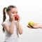 Little girl chooses between two apples, red or green apple, child's choice