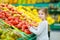 Little girl choosing pomegranate in a food store