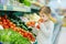 Little girl choosing tomatoes in a food store