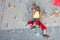 Little girl climbing a rock wall