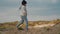 A little girl climbs a hill and walks forward along it.