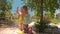 Little Girl Climbs on Small Buddha Statue in Temple Park