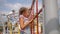 Little girl climbs up rope wall on playground