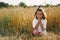 Little Girl closed her eyes, praying in a field wheat. Hands folded in prayer.