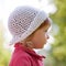 Little girl closeup face in white panama hat side view