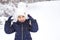 Little girl in the cold winter in warm clothes, with fur-lined ear pads. Joy, laughter, children`s emotions, winter games in the