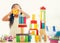 little girl in a colorful shirt playing with construction toy blocks building a tower . Kids playing. Children at day care. Child