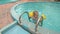 Little Girl Comes out of Pool with Ladder against Water-slide