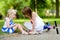 Little girl comforting her sister after she fell while riding her scooter