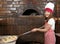 Little girl cook real pizza in pizzeria