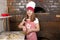 Little girl cook real pizza in pizzeria