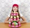 Little girl cook with sweet muffins on table