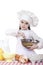 Little girl cook whips whisk eggs in a large plate