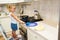 Little girl cooks pancakes in the white kitchen