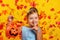 Little girl in a costume of Princess Cinderella with falling autumn leaves. A child holds a pumpkin jack bucket and shows a shh