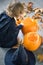 Little girl in a costume of a witch sitting near two pumpkins