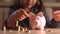 Little girl counting coins and putting coin to pink piggy bank, stack of coin on the table, kid learning to save money for future